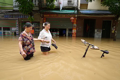 Vietnam Typhoon Yagi: People wade in a flooded street in Hanoi